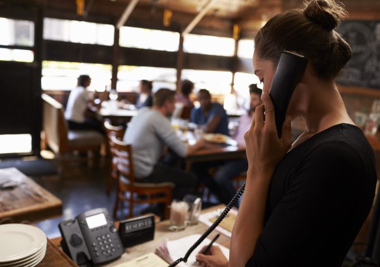 Young,Woman,Taking,A,Reservation,By,Phone,At,A,Restaurant